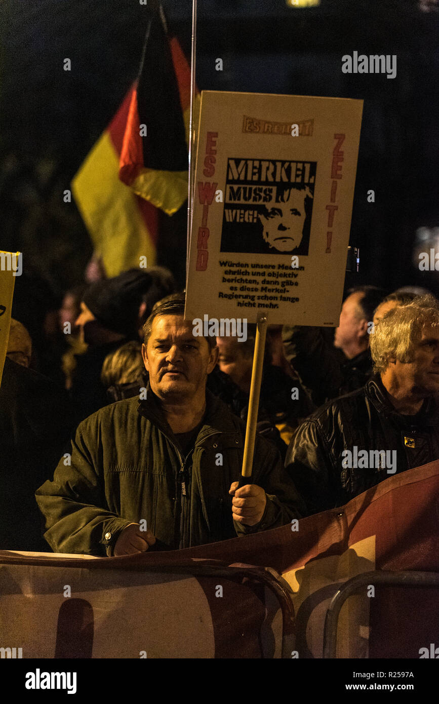 A right wing protester seen holding a placard during the right-wing protest. Right-wing protests against Merkel's visit to Chemnitz, Deutschland. The Chancellor visited the city and talked to the citizens in a citizens' forum after protests and riots broke out in August after a violent death of a 35-year-old man from Chemnitz. Stock Photo