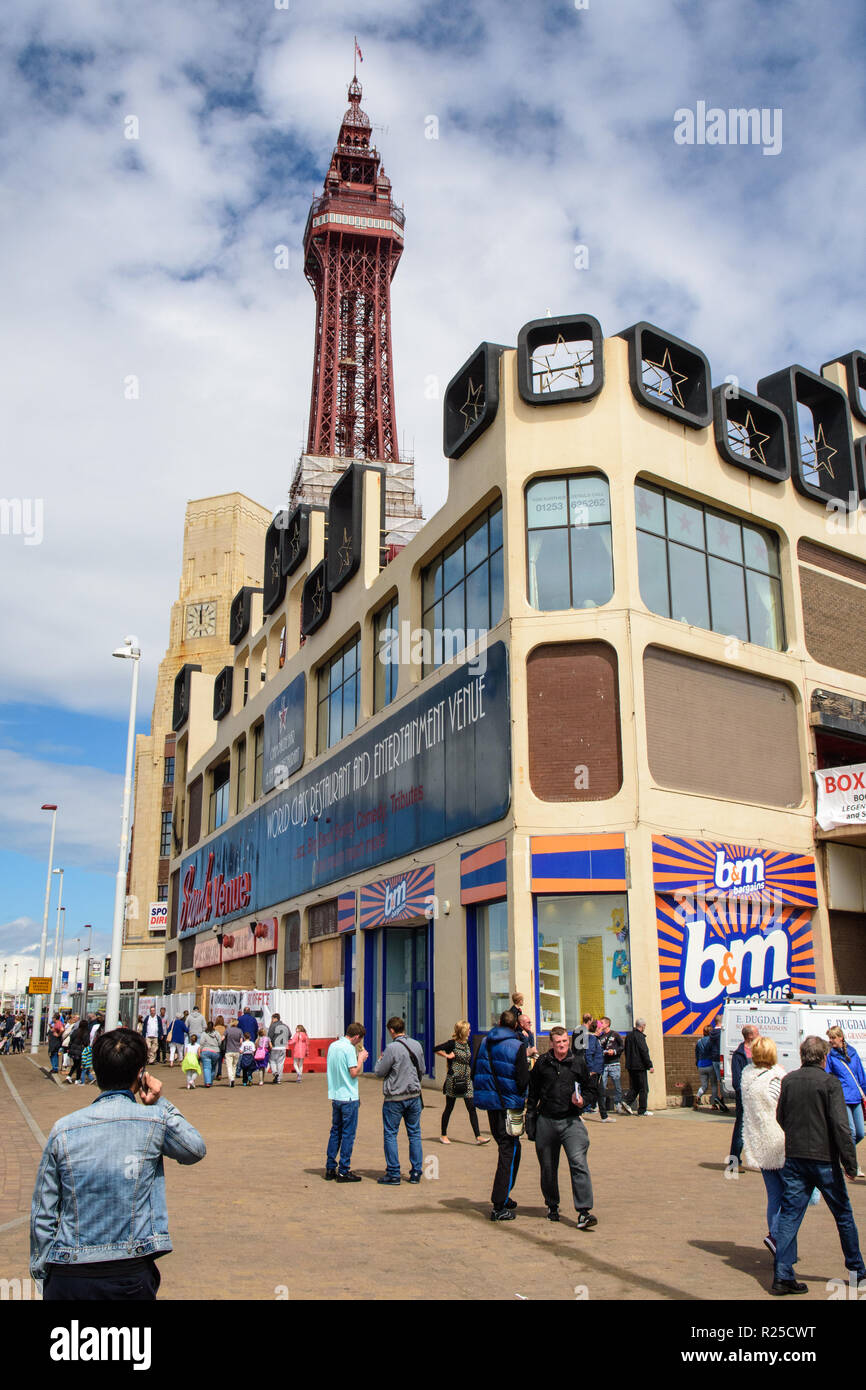 Blackpool, England, UK - August 1, 2015: Shoppers on Blackpool's main shopping steets pass the Blackpool Tower on a summer afternoon. Stock Photo