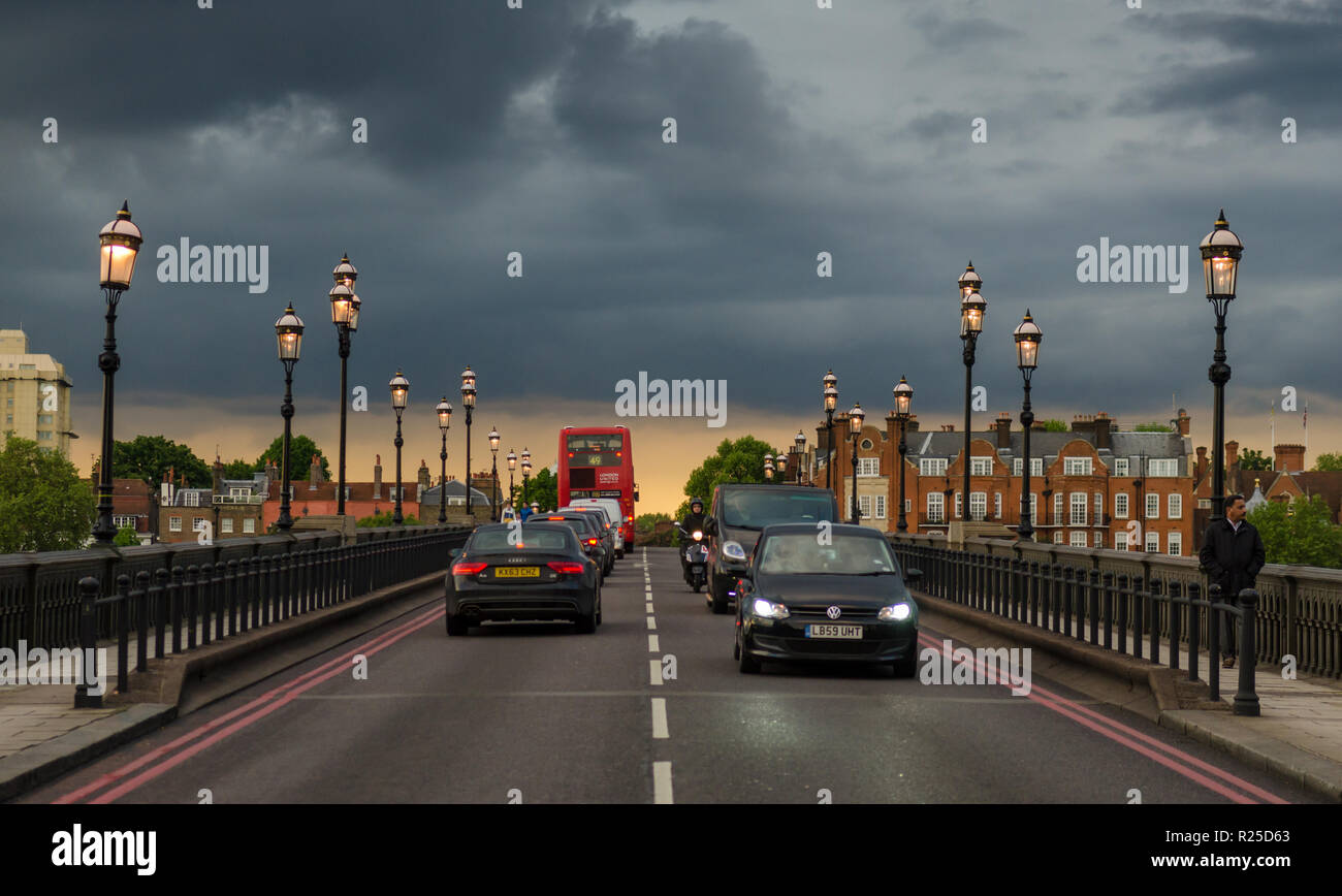 London, England, UK - May 13, 2014: Traffic crosses Battersea Bridge in west London under storm clouds and sunset colours. Stock Photo