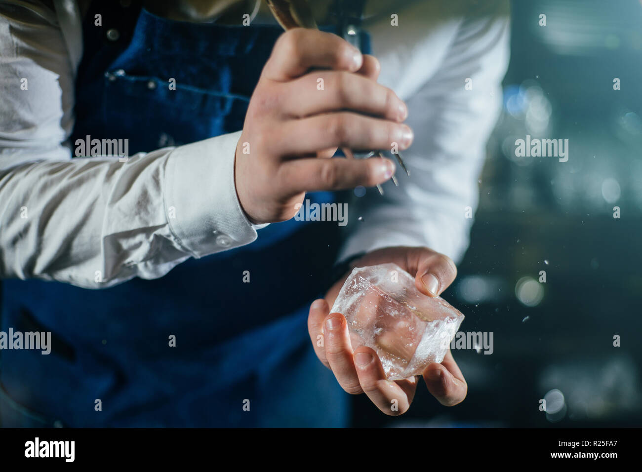 Bartender professionally working with ice to make cold good drinks