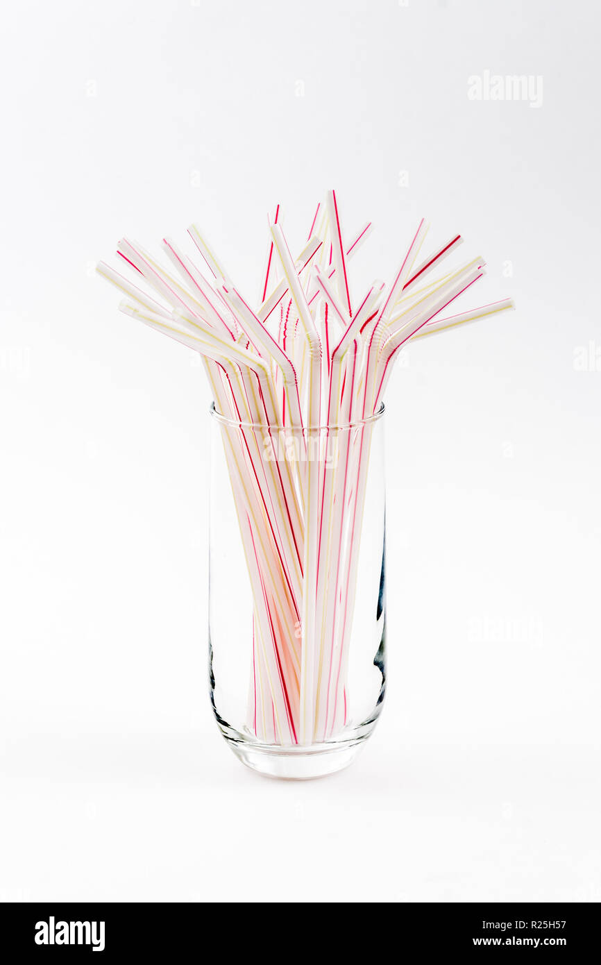 Red stripped straws in glass on white table Stock Photo