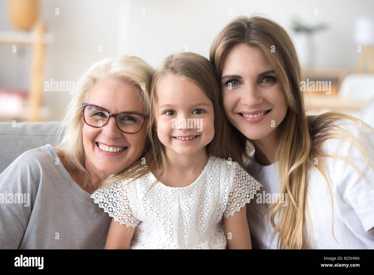 Happy family of grandmother, daughter and child looking at camer Stock Photo