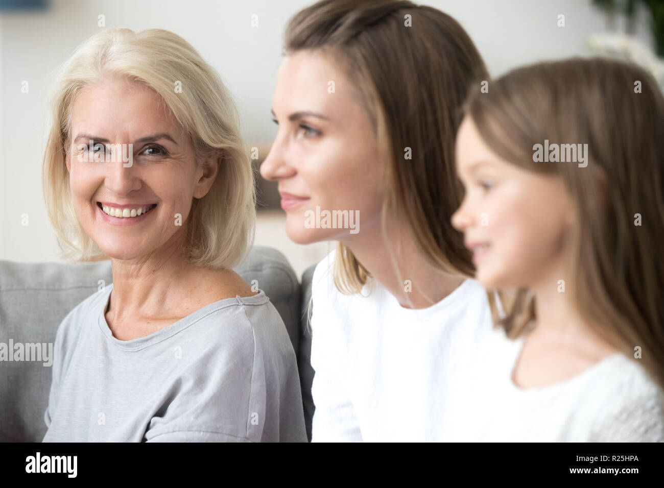 Portrait of smiling grandmother near grown daughter and kid gran Stock Photo