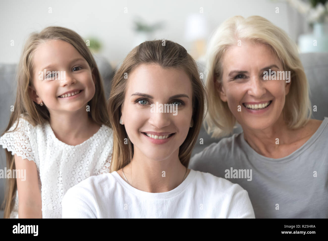Smiling young woman with old mother and kid daughter portrait Stock Photo