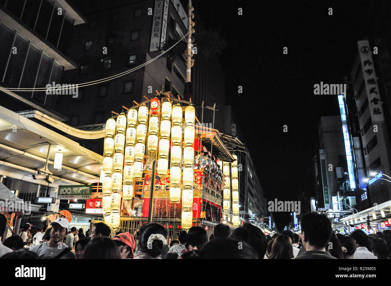 KYOTO, JAPAN - JULY 15, 2011: A portable shrine covered in red and gold embroidered cloth and attached to glowing paper lanterns Stock Photo