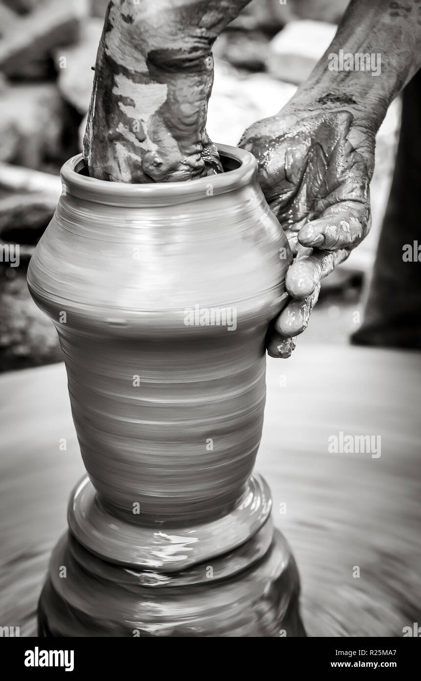 Hands of a man creating pottery on wheel, monochrome vintage style view Stock Photo