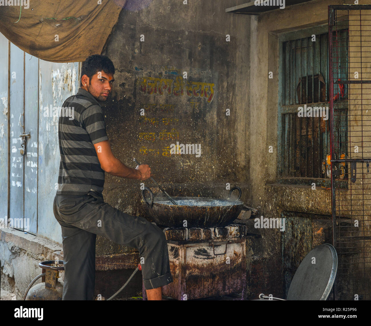 Jodhpur, India - Nov 6, 2017. A man cooking traditional food on street in Jodhpur, India. Jodhpur is the second largest city in state of Rajasthan. Stock Photo