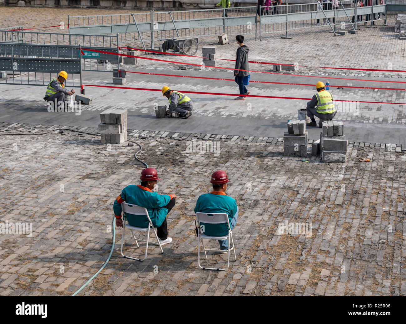 Supervisors oversee repair of paving slabs in Forbidden City Stock Photo