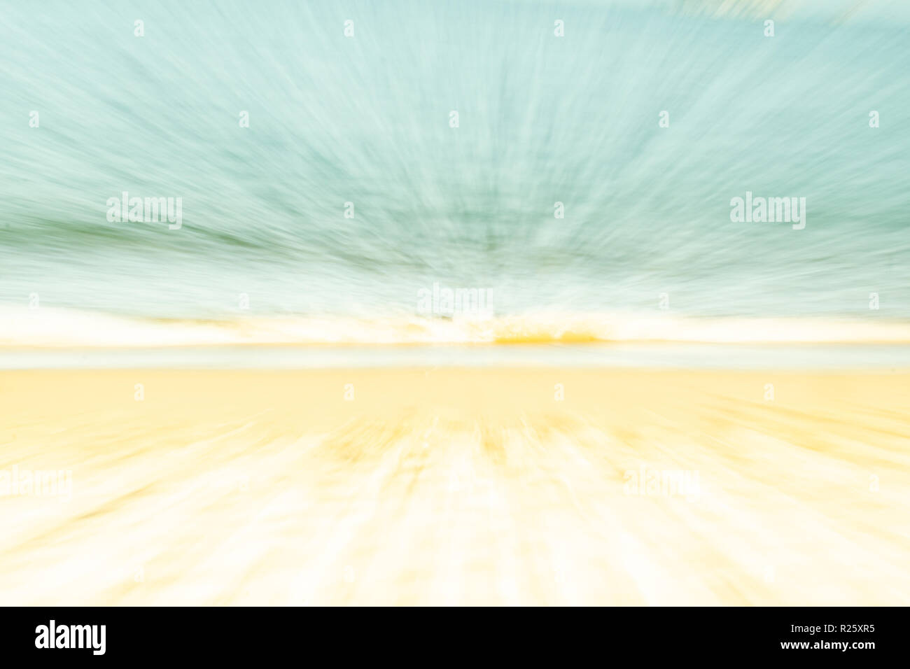 Backgrounds soft hues coastal abstract golden sand blue water and pale sky in zoom blur Stock Photo
