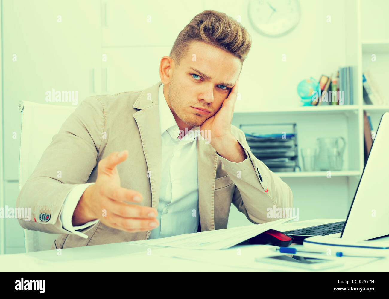 Frustrated young man having business problems with papers at workplace Stock Photo