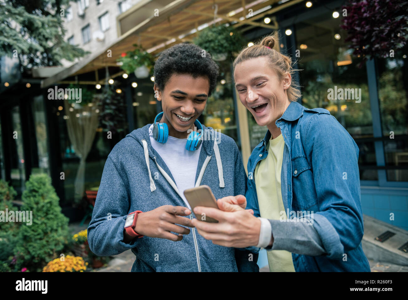 Delighted male friends discussing a new smartphone Stock Photo