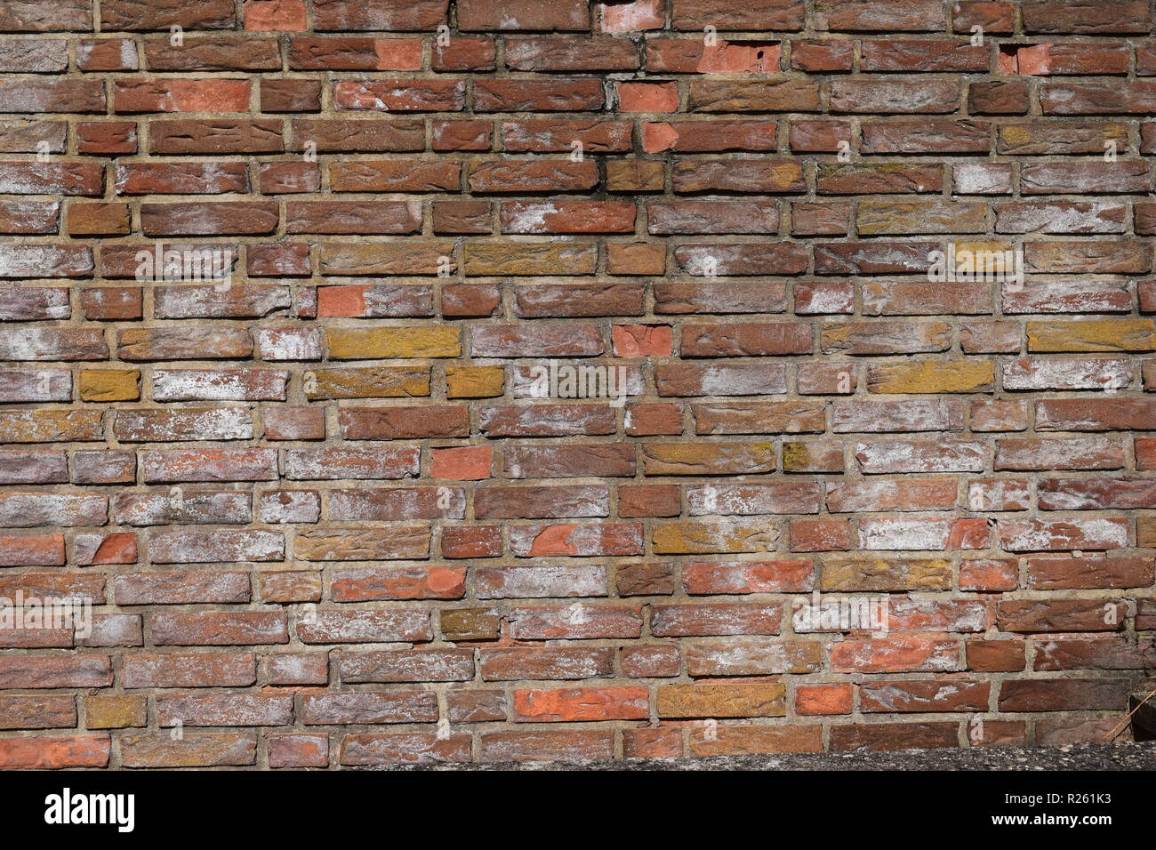 Old red brick wall showing signs of age and decay mortar. Stock Photo