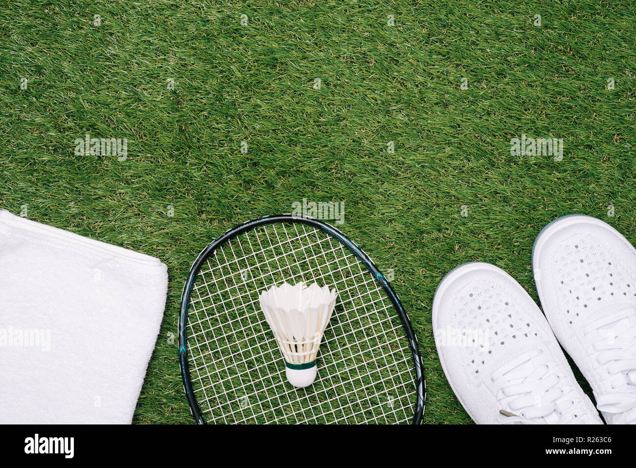 sports set of blue sport shoes and shuttlecocks with badminton racket on grass background in concept family activity Stock Photo