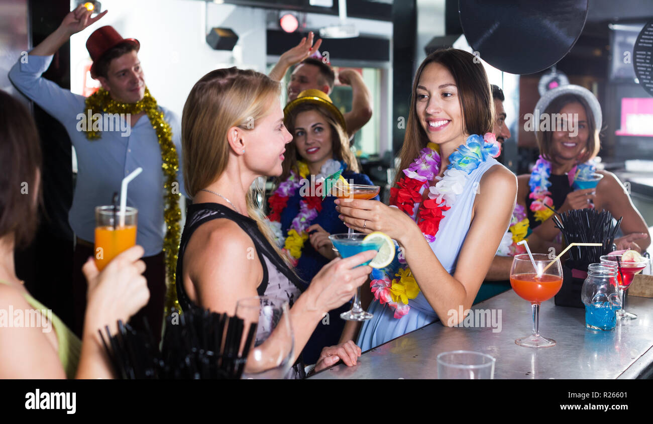 Young cheerful women are drinking cocktails on hawaiian party in ...