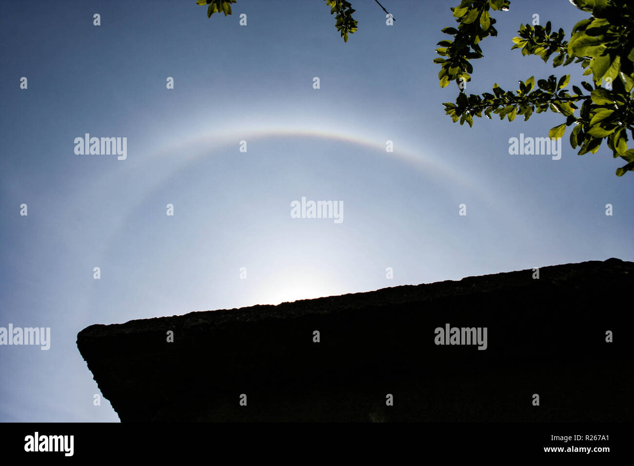 Various sun halos appearing in the sky over Romania. Rare natural phenomenon. Bright 22 degrees and upper tangent arc. Stock Photo