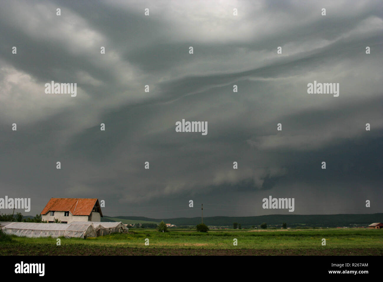 A dramatic looking shelf cloud is approaching the Mures valley in Transylvania, Romania. Stock Photo