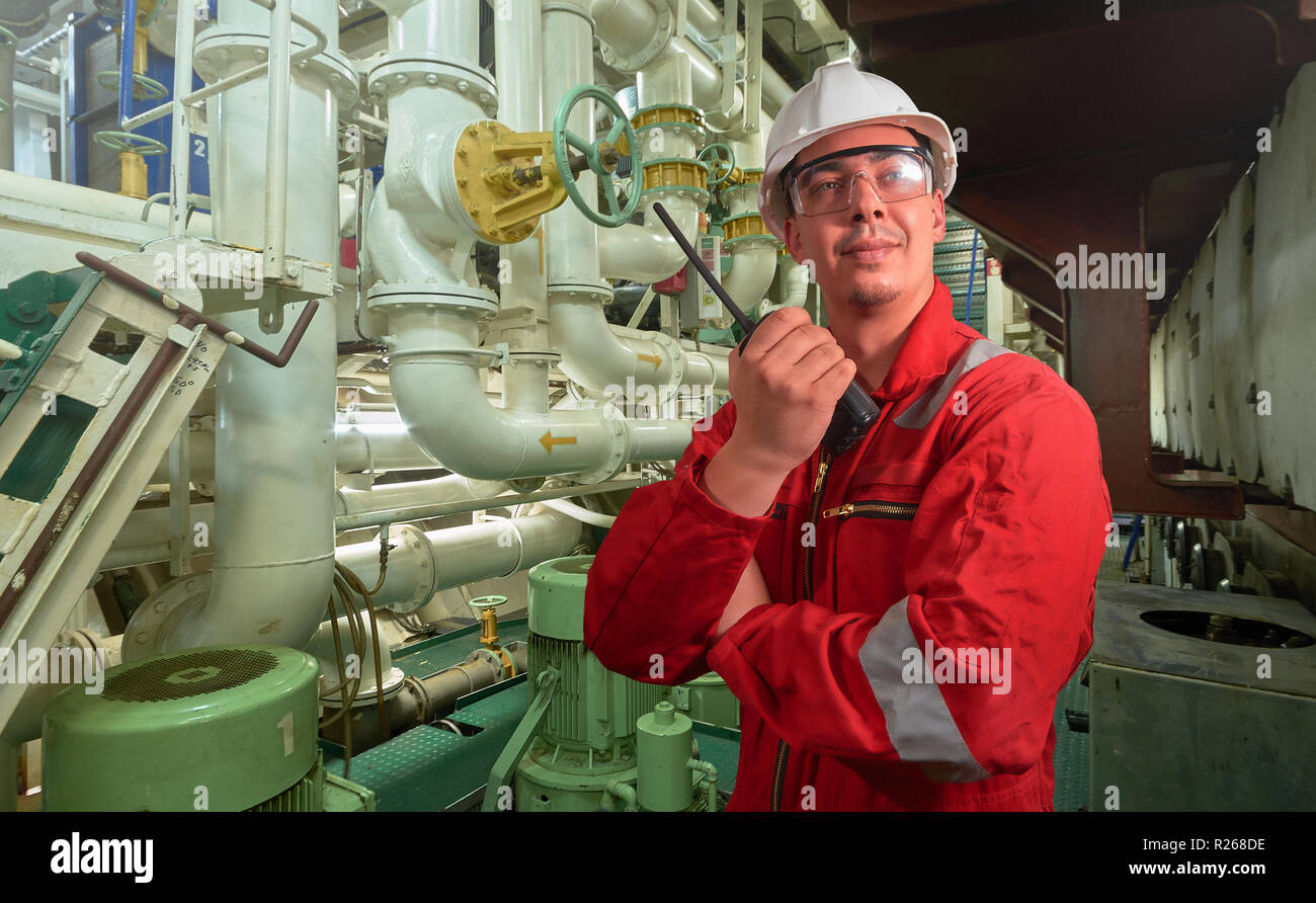 Ship's mechanic near marine diesel generators on a merchant ship in the
