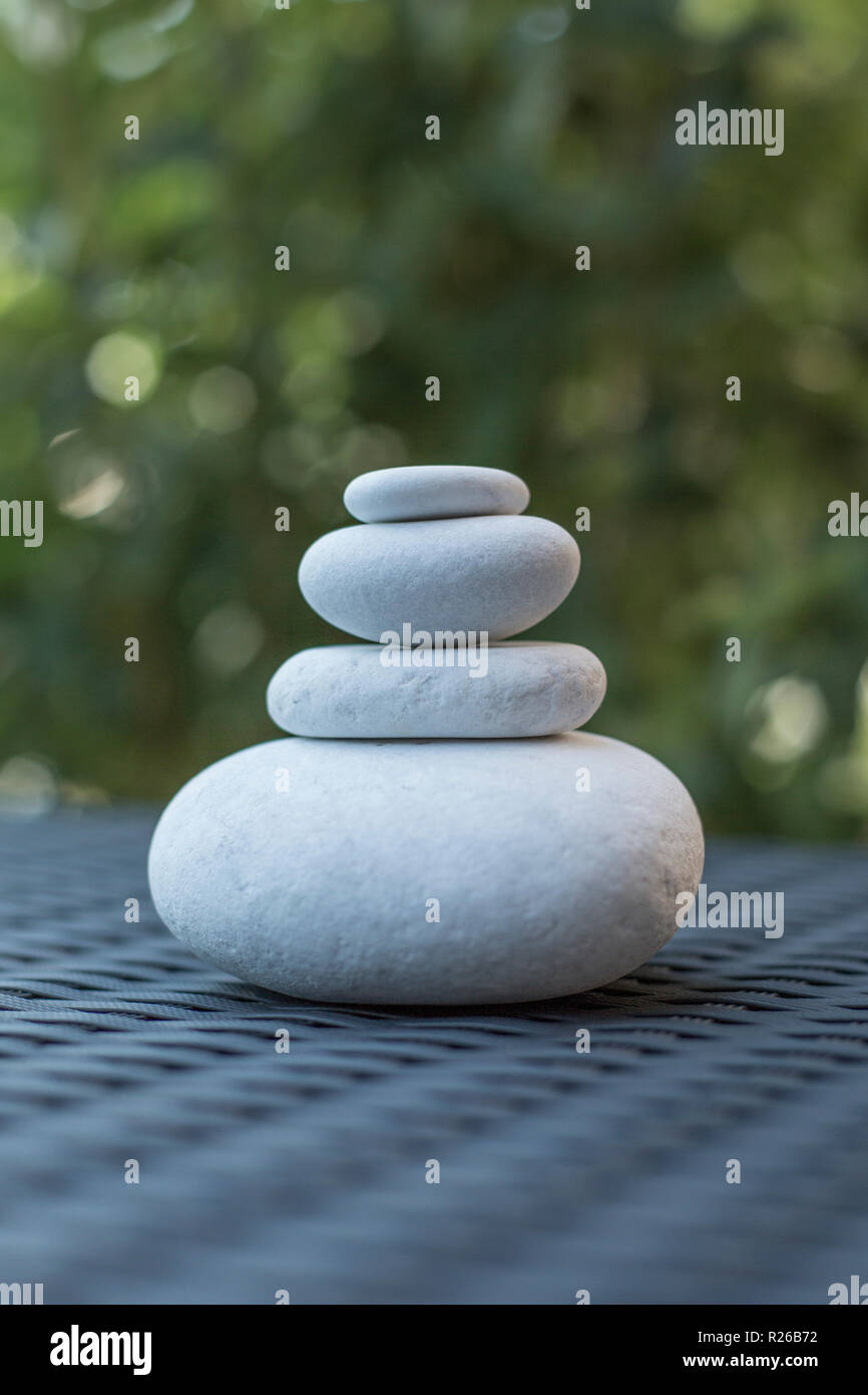 Pile of pebbles on rattan style surface - garden deco and zen balance concept Stock Photo