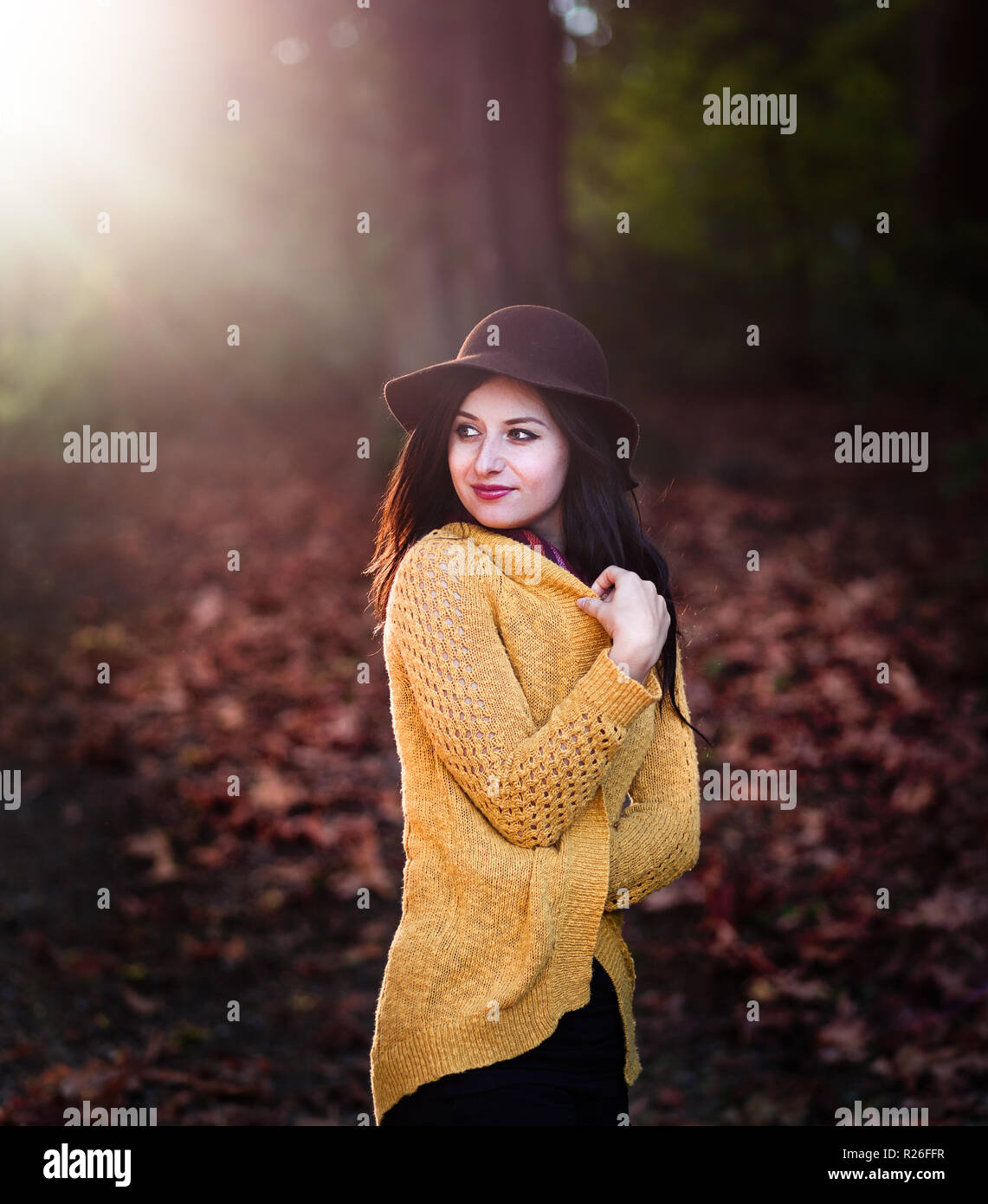Girl in a park with autumn leaves around her Stock Photo - Alamy
