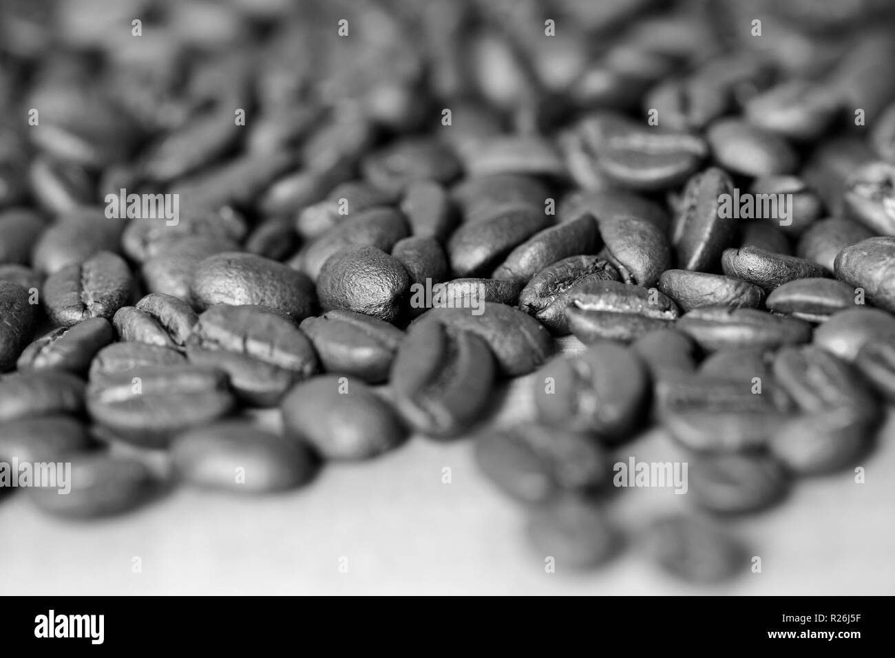 Roasted coffee beans on a wooden background. Black and white Stock