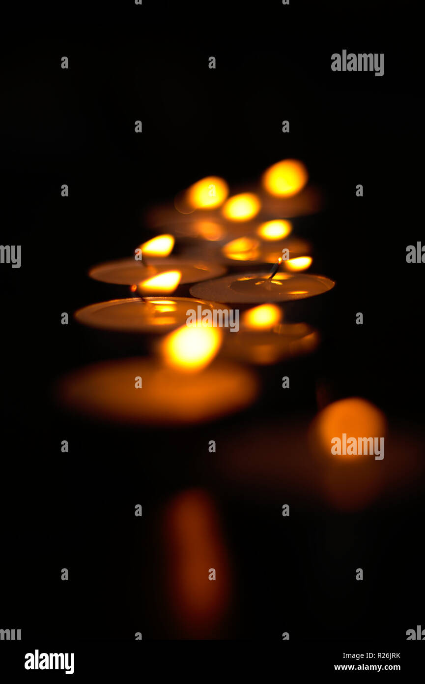 Tealight candles burning in the dark Stock Photo