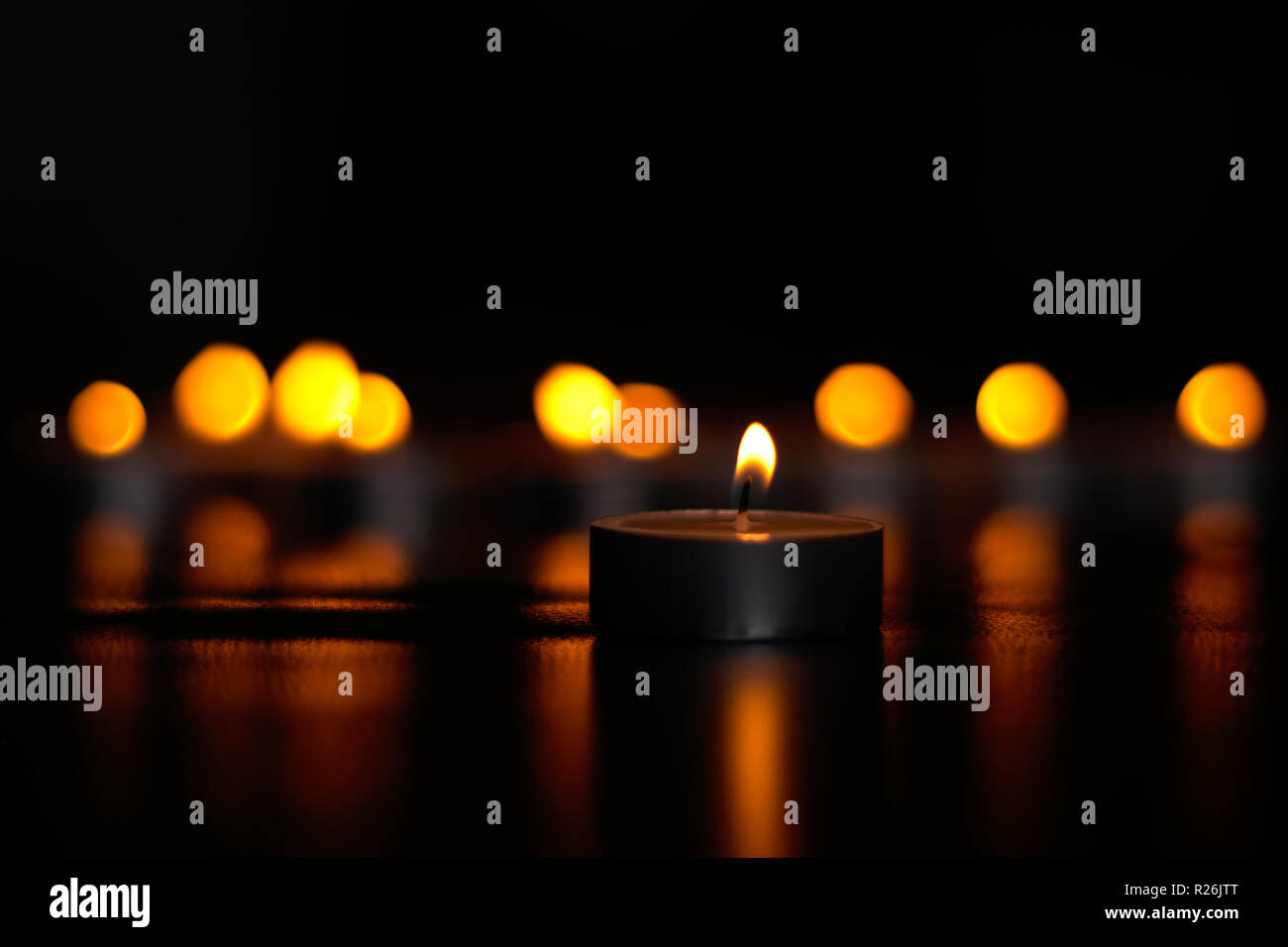 Tealight candles burning in the dark Stock Photo