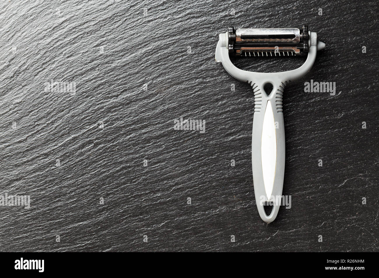 Device for peeling fruits and vegetables, peeler, on a black background, space for text Stock Photo