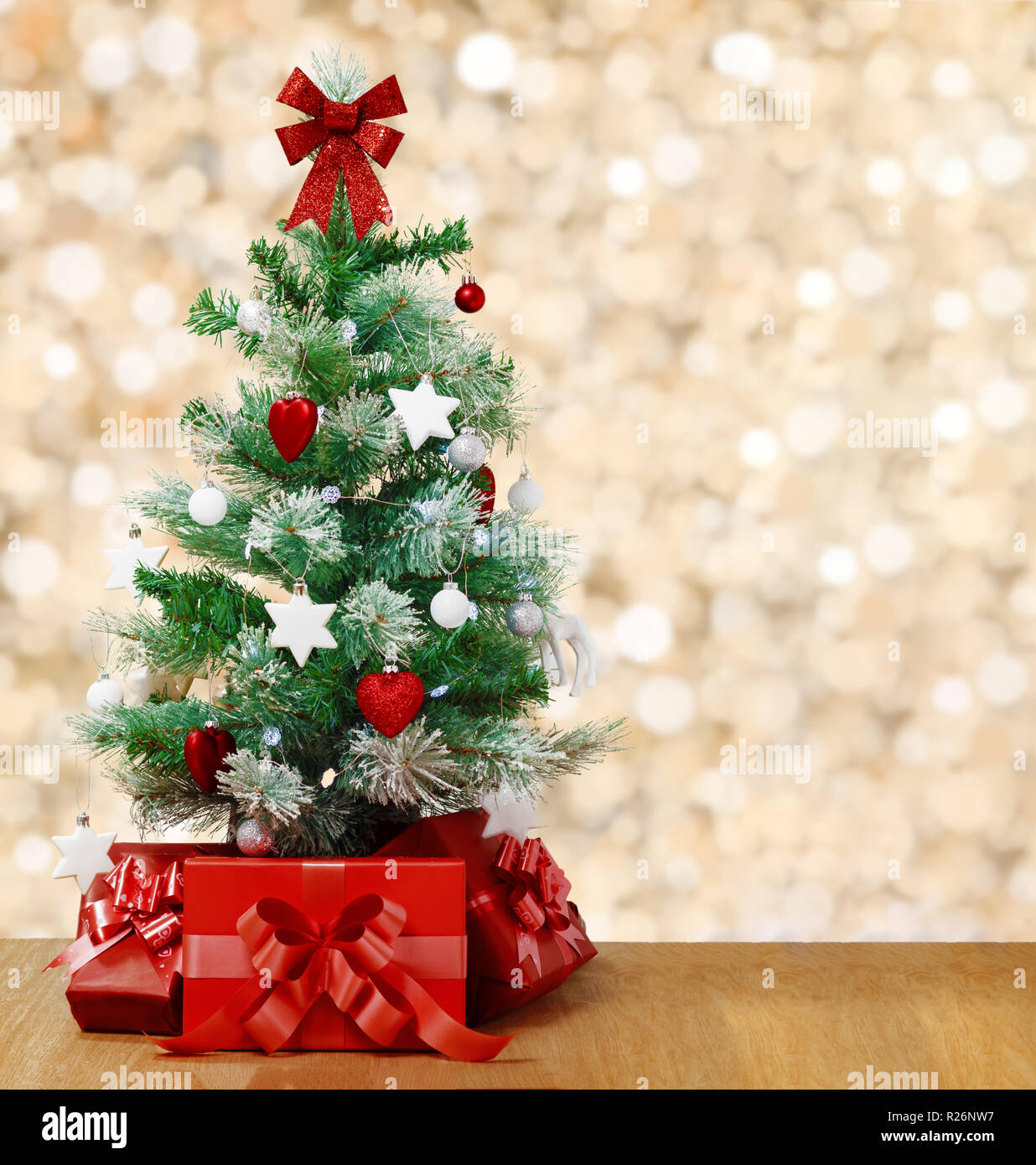 Under the decorated Christmas tree are red boxes with gifts. Tree on
