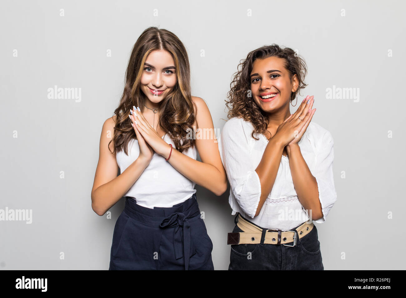 Portrait of pretty charming girls in casual outfits isolated on bright gray background with copyspace for advertising Stock Photo