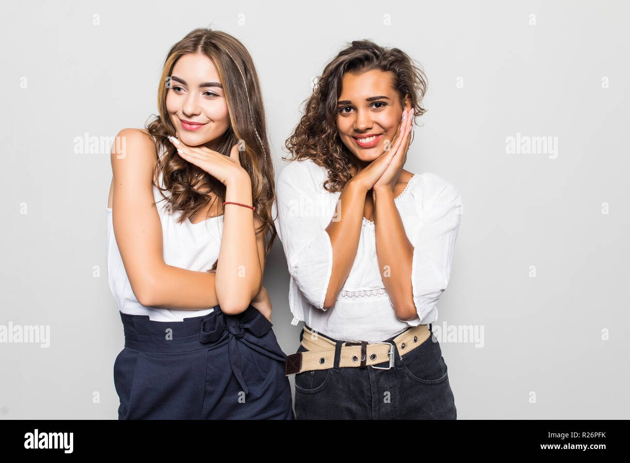 Portrait of pretty charming girls in casual outfits isolated on bright gray background with copyspace for advertising Stock Photo