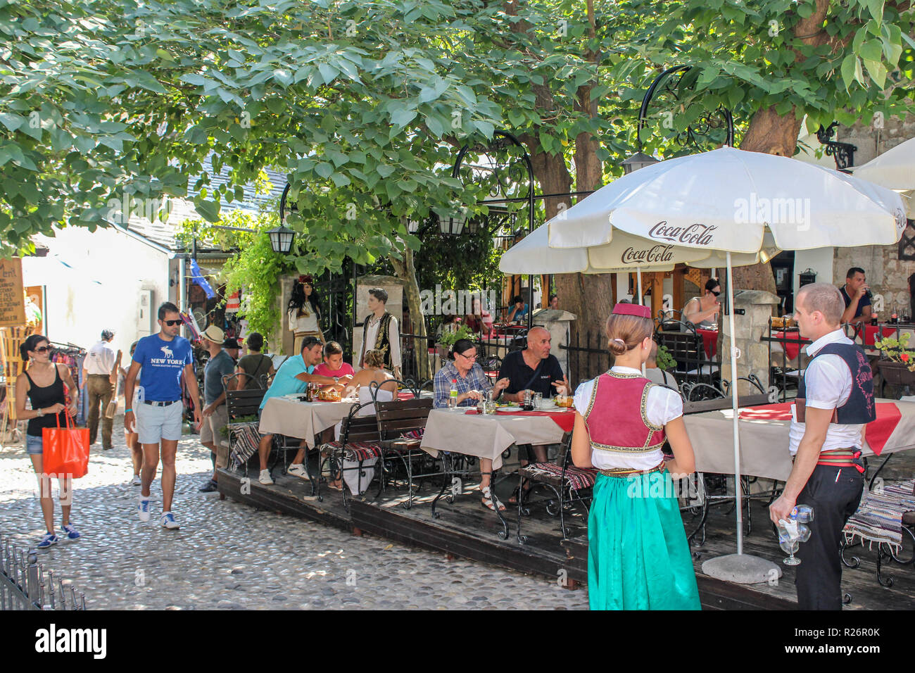 August 2013, Mostar. Outdoor restaurant with guests dining out side.  The waiters are dressed in traditonal costumes in the Old Towm. Stock Photo