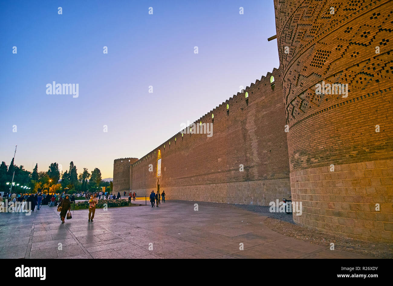 SHIRAZ, IRAN - OCTOBER 14, 2017: The frontage wall of Karim Khan citadel stretches along the crowded Shohada Square, decorated with flower beds and or Stock Photo