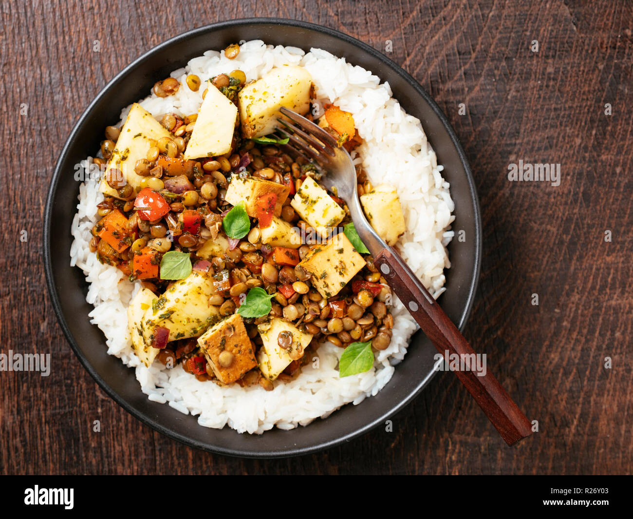 Sweet sour lentils with fresh pineapple and smokey tofu served on rice. Stock Photo