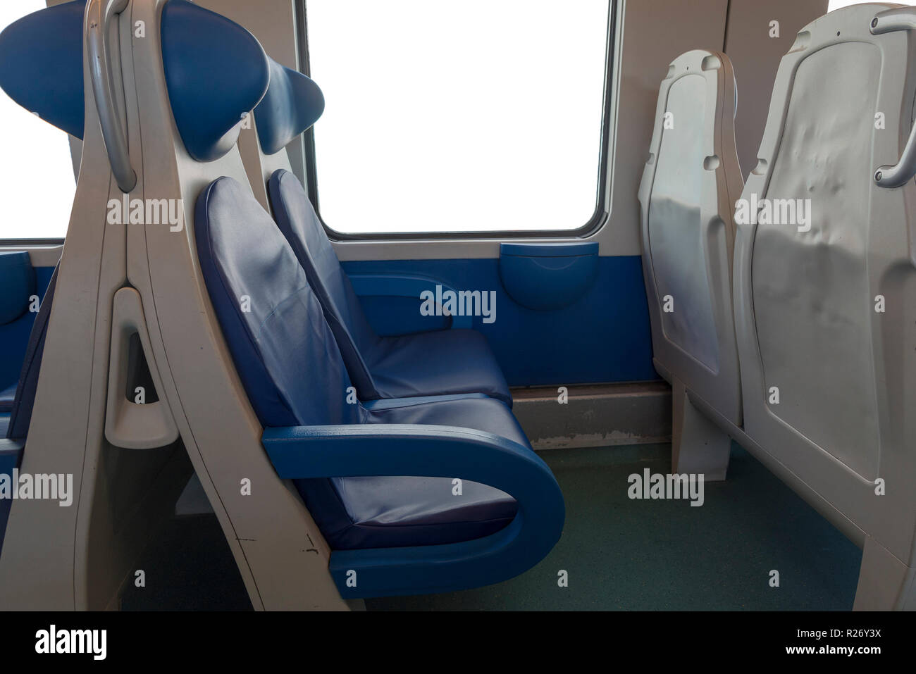 Inside the cab of the modern Express. Nobody in blue chairs by the window. Fuzziness. Comfortable chairs and table in the foreground, white background Stock Photo