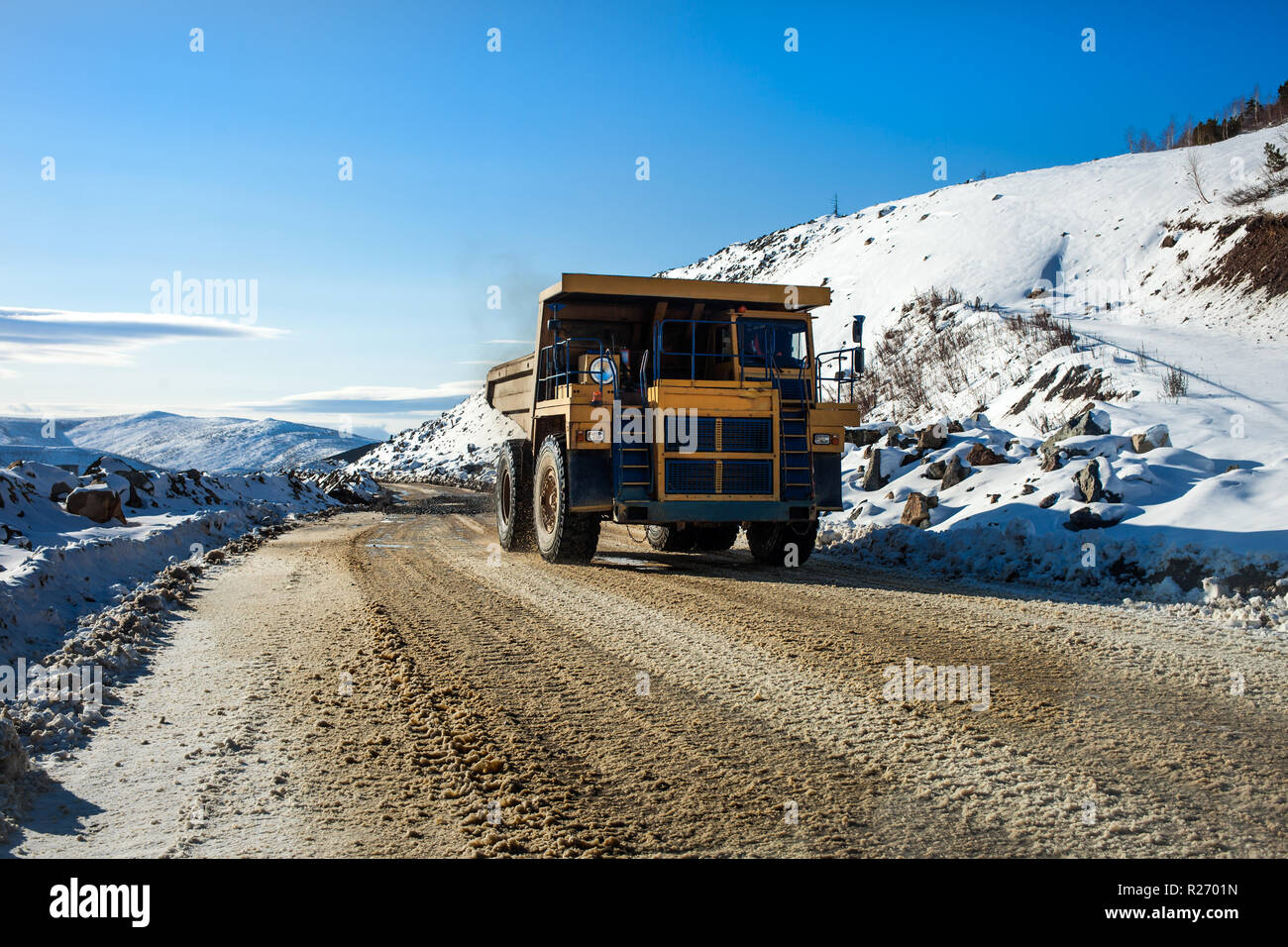 Yellow dump truck on a road Stock Photo - Alamy