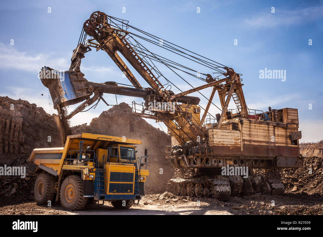 Excavator loading dump truck at coal mining Stock Photo