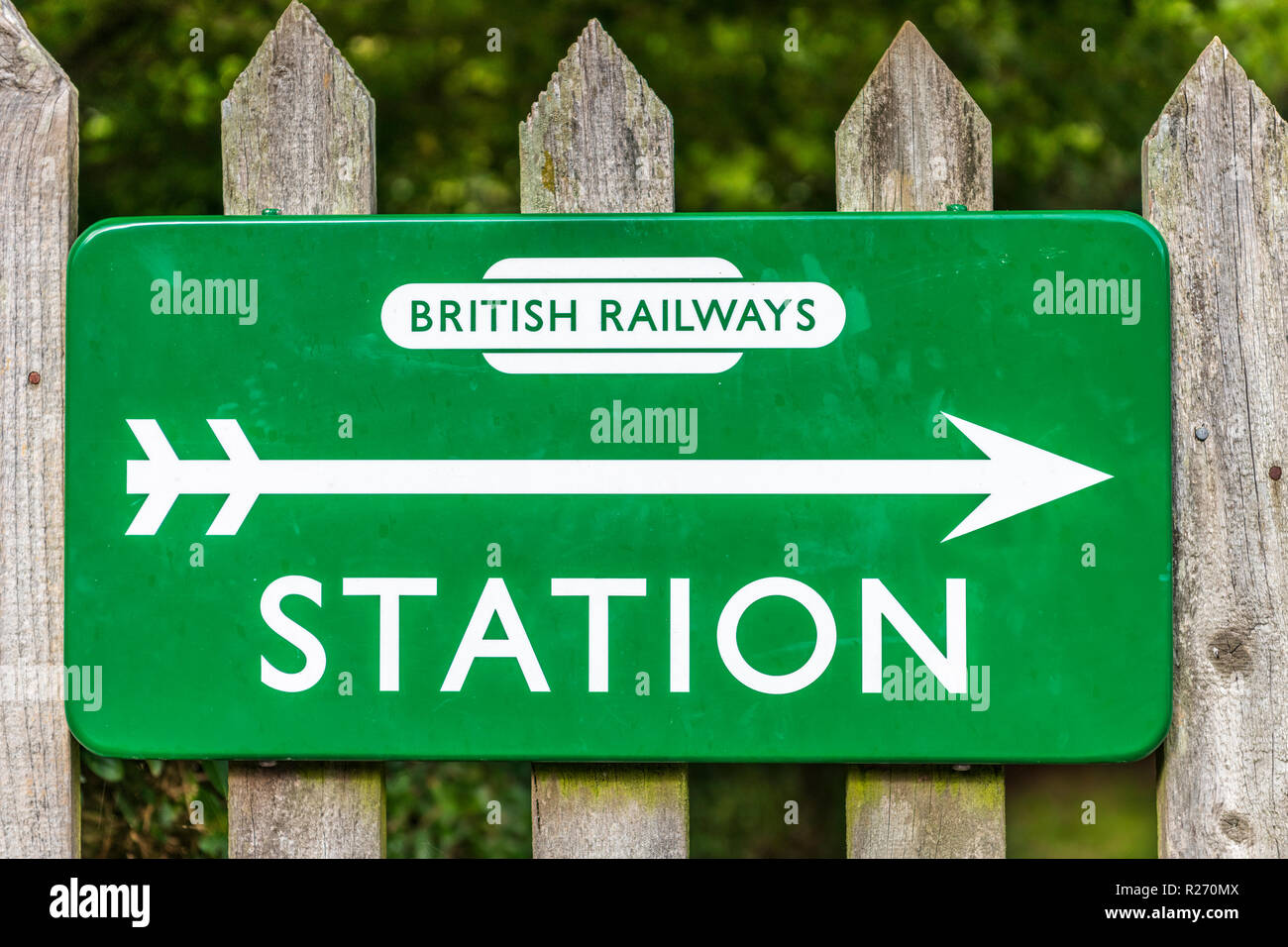 A classic British Railways Station sign attached to a fence near a small branch line. Stock Photo