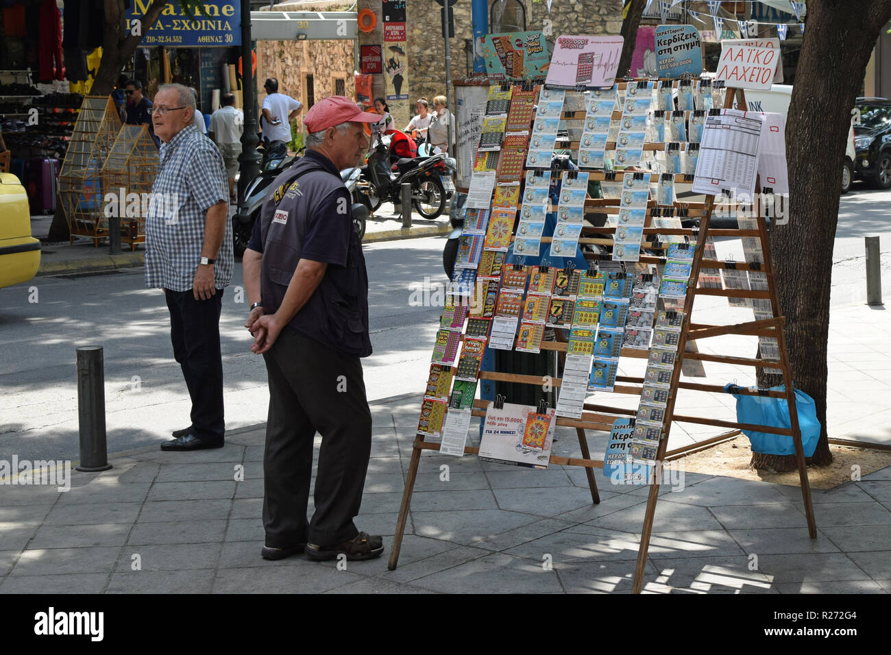 ATHENS, GREECE - AUGUST 29, 2018: Man selling lottery tickets on busy street in downtown Athens. Stock Photo
