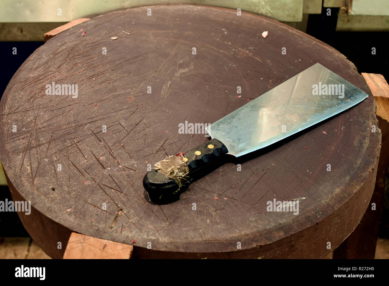 Bloody meat cleaver on wooden butchers cutting board. Stock Photo