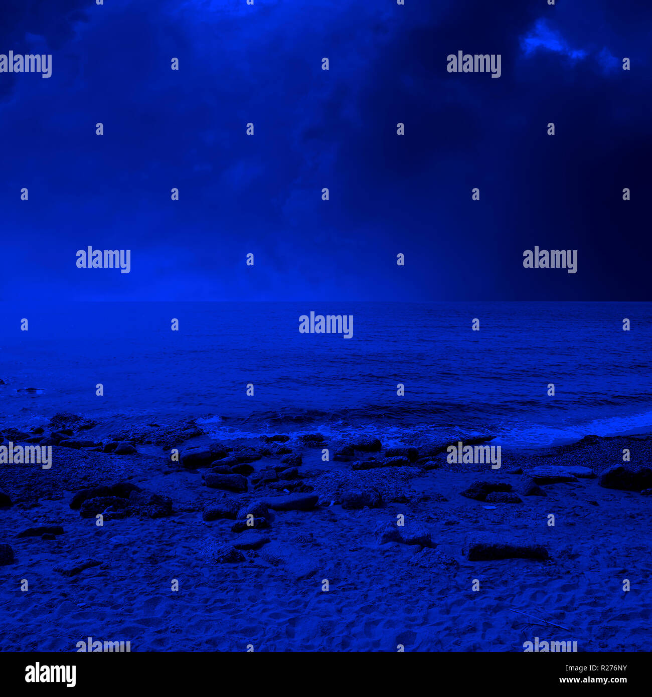 seascape image of sandy and rocky beach over stormy sky Stock Photo - Alamy