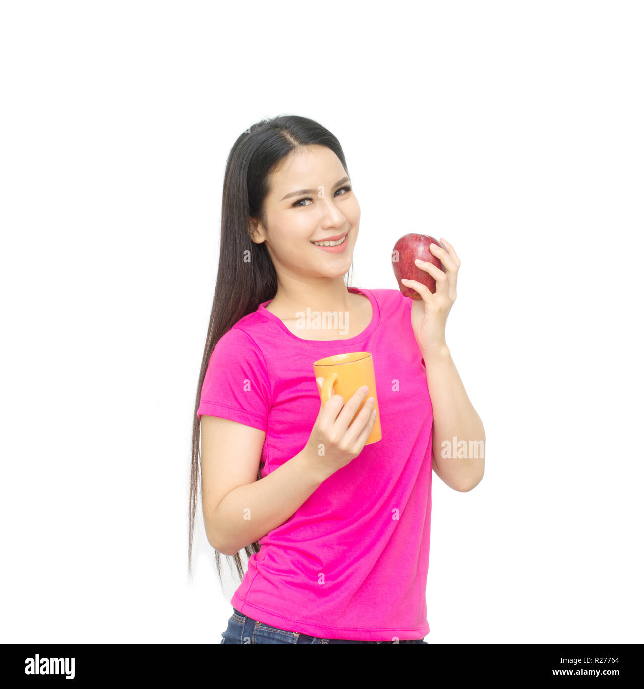 Portrait of asian young woman with cup of drinking water ,tea or coffee and one hand holding red apple isolated on white background. Stock Photo