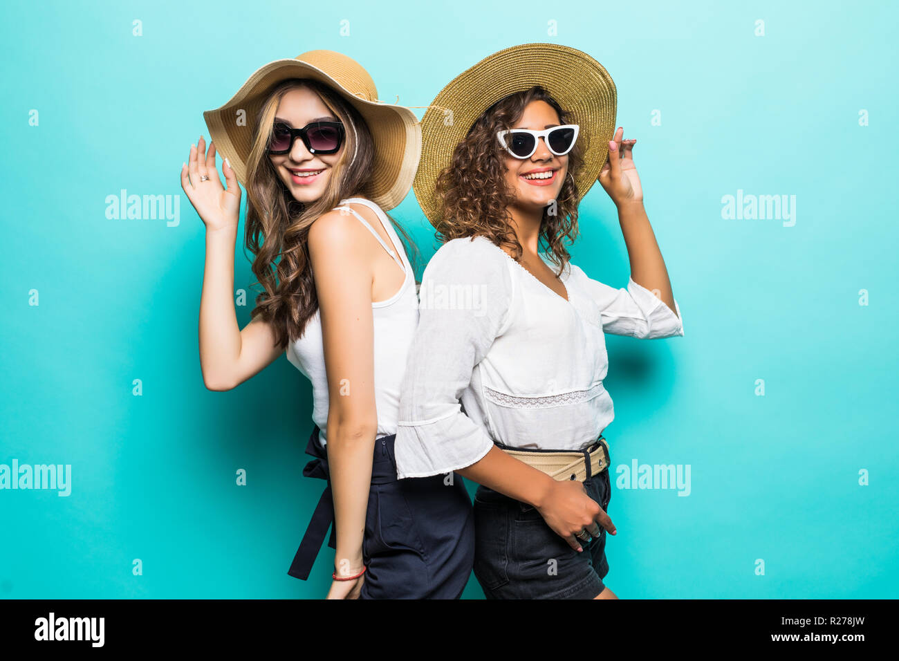 Portrait of two girls with different type of skin wearing straw hats ...