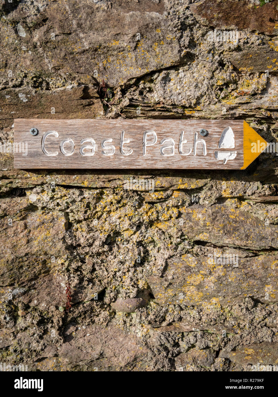 A wooden directions footpath sign for the coastal path in Combe martin