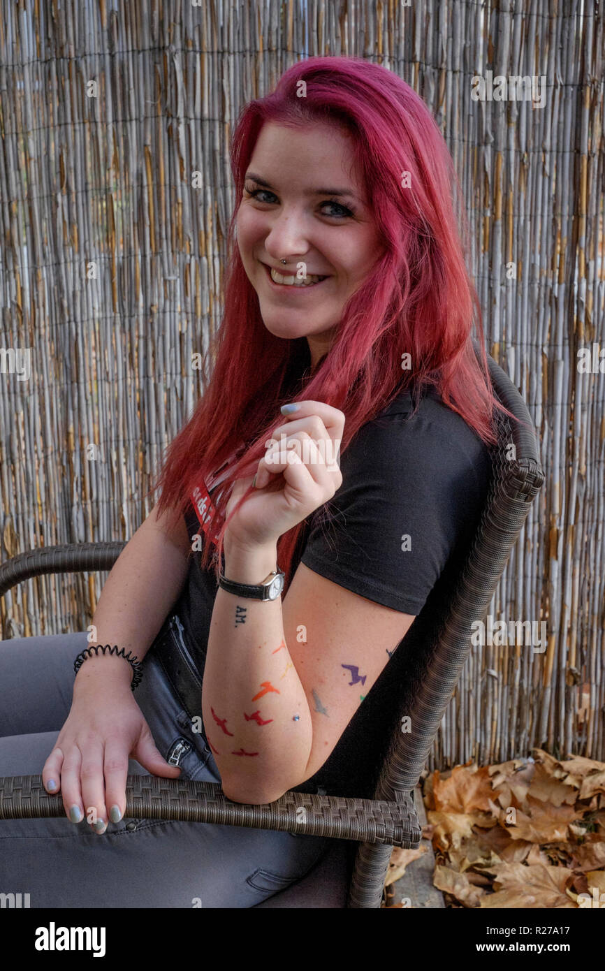 portrait of a smiling young female with red dyed hair and bats tattooed on her arm lenti zala county hungary Stock Photo