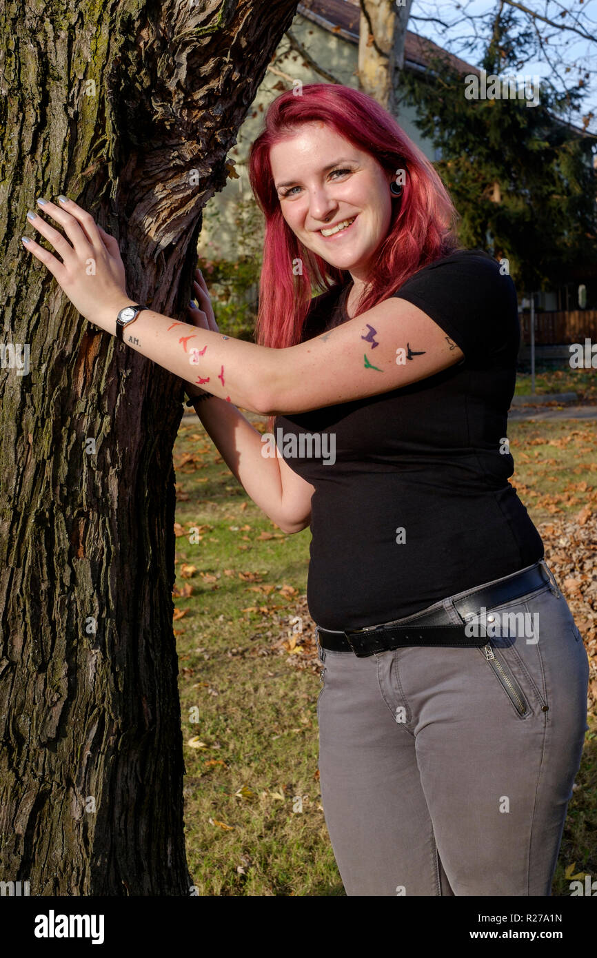 portrait of a smiling young female with red dyed hair and bats tattooed on her arm lenti zala county hungary Stock Photo
