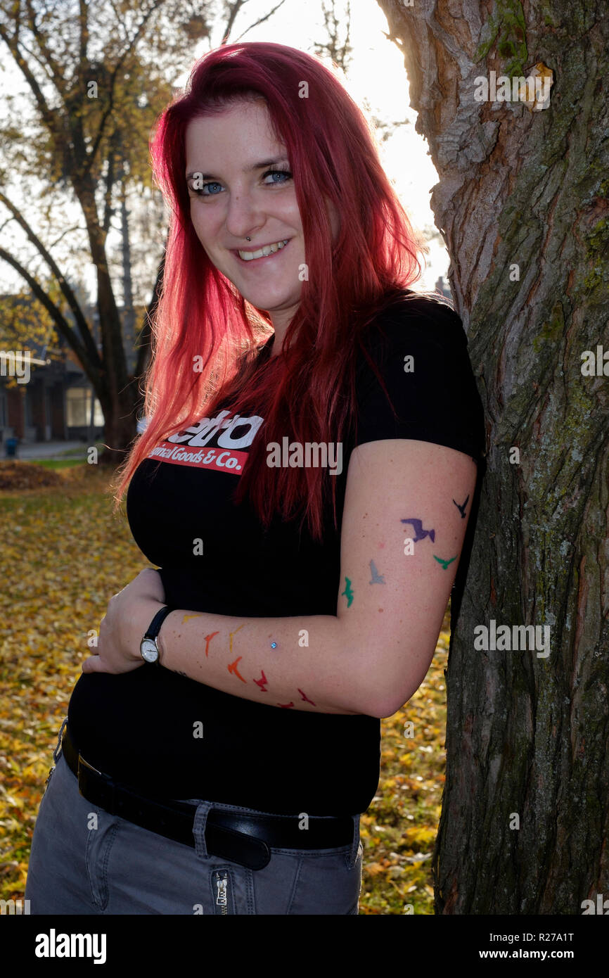 portrait of a smiling young female with red dyed hair and bats tattooed on her arm lenti zala county hungary Stock Photo