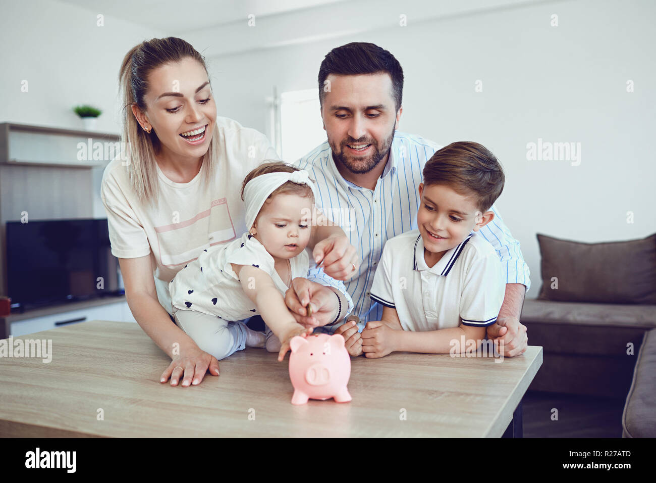 Family and piggy bank hi-res stock photography and images - Alamy