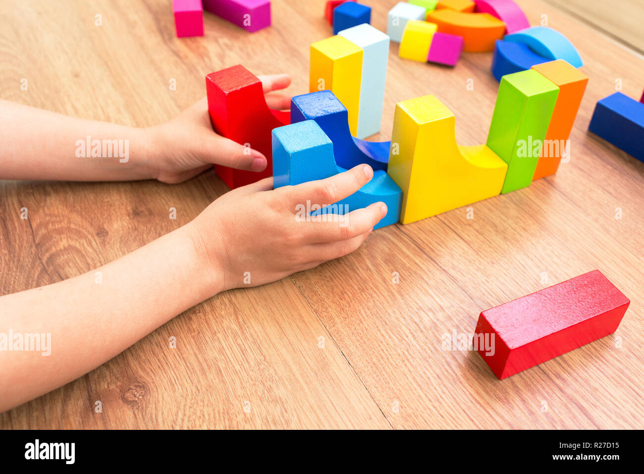 A child plays with colored blocks, colored cubes constructs a model on ...