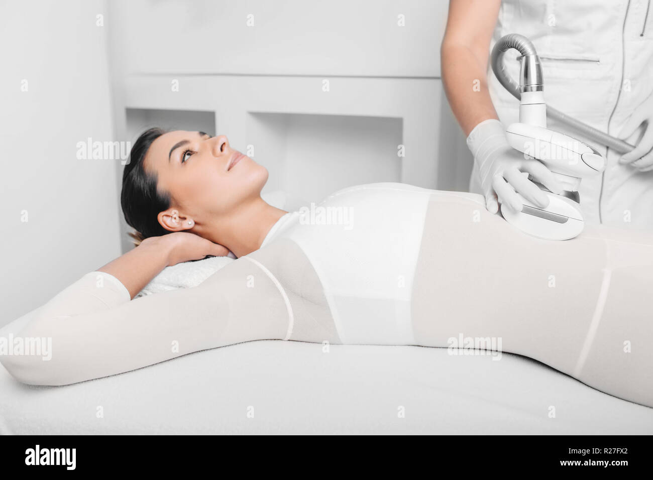 Beautiful woman receiving lpg massage against cellulite on belly Stock