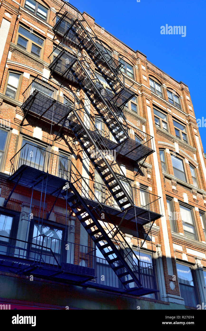 Downtown Boston, Massachusetts, older building with external fire escape zig zagging down outside in alley Stock Photo